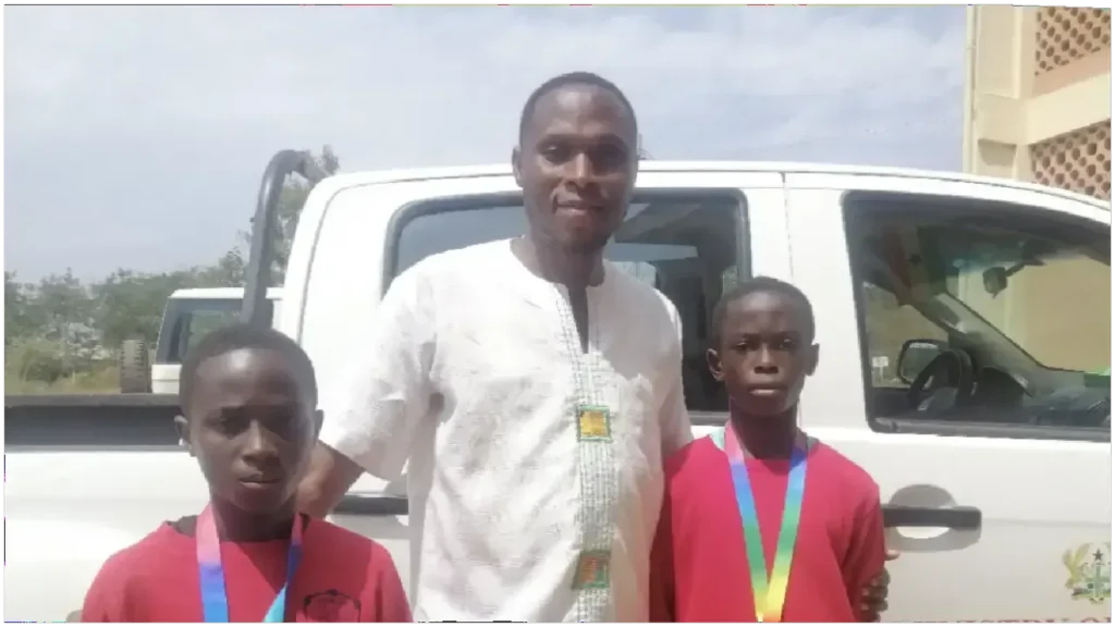 photo of Sports Coordinator with 2 Besoro Under-13 star players