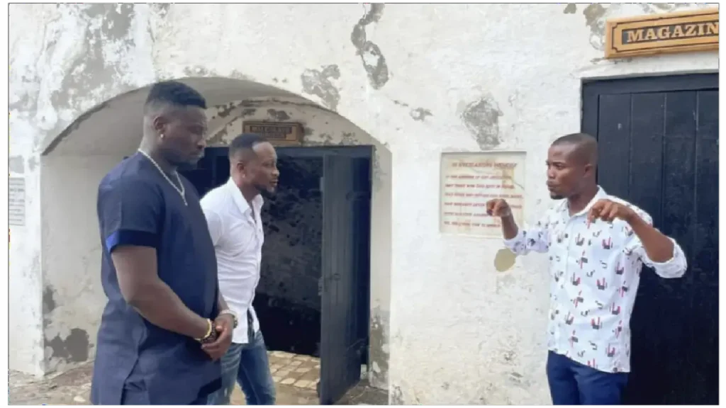 picture of Asamoah Gyan receiving brief history of Cape Coast Castle