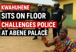 Traditional chief Daasebre Akuamoah Boateng III sitting on the ground in front of police officers during a standoff at Abene Palace.