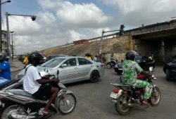A street scene in Cotonou during reports of a coup attempt claim, with security forces and motorists visible